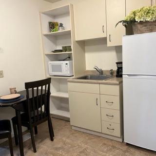 Small apartment kitchen with essential appliances and furniture.