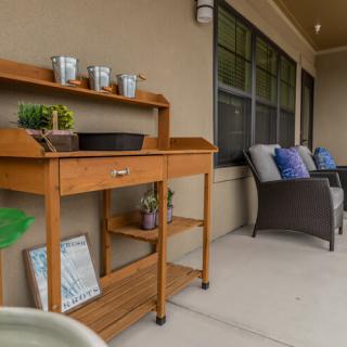 A cozy patio setup with a wooden cart and comfortable seating.