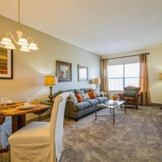 A cozy living room and dining area with comfortable furnishings and warm lighting.