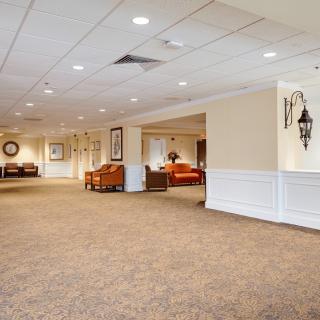 A spacious lobby interior with carpet flooring and comfortable seating areas.