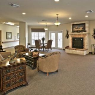 A modern living space featuring a cozy seating area and a fireplace, complemented by elegant decor and a dining table.