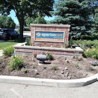Entrance sign for a business surrounded by landscaped garden.