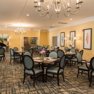 An elegantly decorated dining room with chandeliers and neatly arranged tables and chairs.