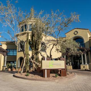 A modern residential building with distinctive architecture surrounded by trees on a sunny day.