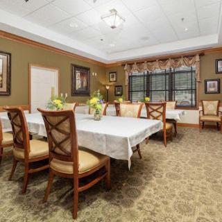 A spacious and elegantly decorated dining room featuring a large table, comfortable chairs, and tasteful artwork.