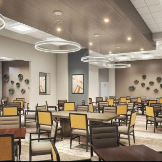 A modern dining area with stylish lighting and neatly arranged tables and chairs.