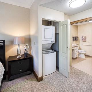 A cozy bedroom with an adjacent laundry area and bathroom.