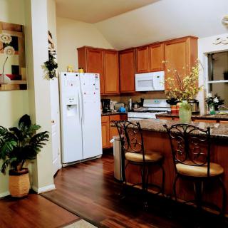 A cozy kitchen with wooden cabinets, white appliances, and inviting decor.