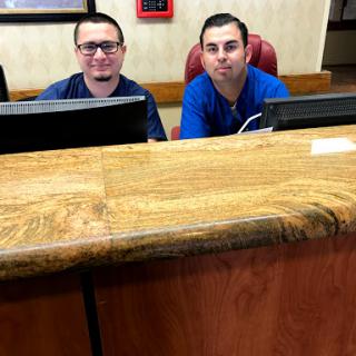 Two staff members smiling at the reception desk.