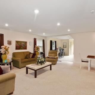 A spacious and well-lit living room featuring comfortable sofas, a coffee table, and decorative elements.