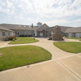 A well-maintained building with landscaped gardens and a clear sky.