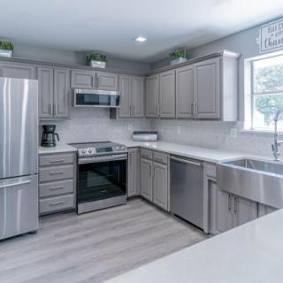 A modern kitchen with stainless steel appliances and gray cabinets.
