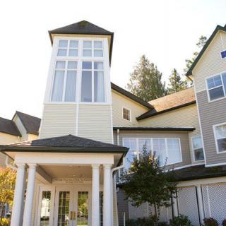 A modern residential building with large windows and a prominent entryway.