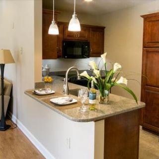 A modern kitchen with a sleek countertop, pendant lighting, and elegant decor.