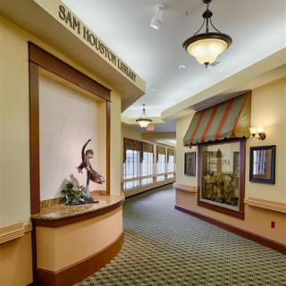 A well-lit hallway in a hospital featuring decorative elements and artwork.