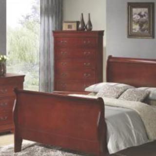 A cozy bedroom with wooden furniture including a sleigh bed, a dresser, and a chest of drawers.