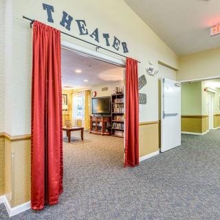 The entrance to a theater room with red curtains and a carpeted hallway.