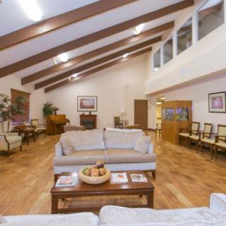 A spacious and inviting living room featuring elegant furniture and a warm wooden floor.