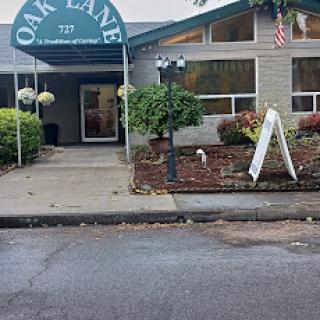 Entrance of Oak Lane, featuring a welcoming sign and well-maintained landscaping.