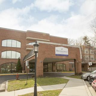 A modern healthcare facility with a brick exterior and designated parking area.