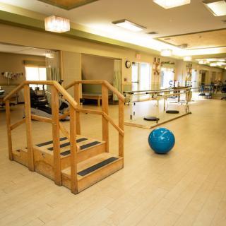 A rehabilitation room equipped for physical therapy with exercise equipment.