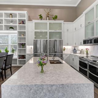 A modern kitchen with white cabinets and stainless steel appliances.