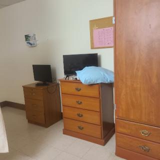 A simple bedroom setup featuring two dressers and two televisions.
