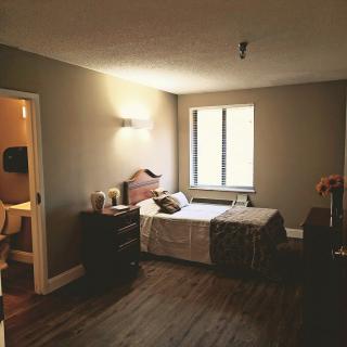 A cozy bedroom with a single bed, dresser, and window.