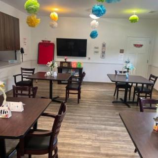 A well-decorated dining area with colorful hanging decorations and neatly arranged tables and chairs.