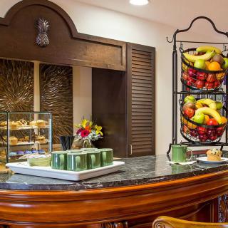 A breakfast buffet setup with a variety of fruits and pastries on display.
