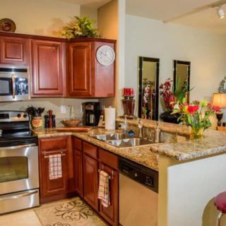 A modern kitchen interior with wooden cabinets and stainless steel appliances.