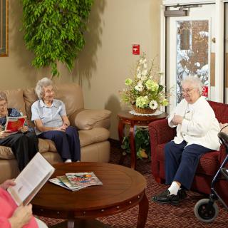 A group of seniors having a conversation in a cozy living room setting.
