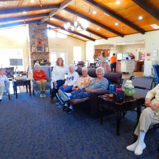 A group of seniors gathered in a cozy living room setting.