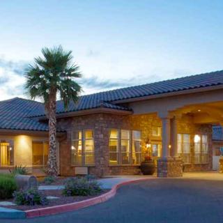 A beautifully lit building with palm trees at dusk.