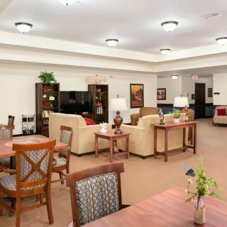 A cozy living area with comfortable sofas, tables, and warm lighting.