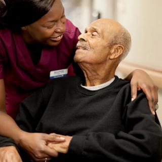 A nurse providing care and support to an elderly man.