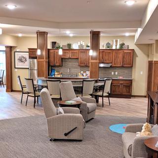 A spacious living area with a cozy seating arrangement and an open kitchen layout.