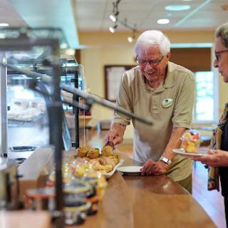 Seniors enjoying a meal at a buffet-style dining area.