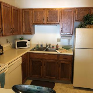 A cozy kitchen with wooden cabinets and essential appliances.