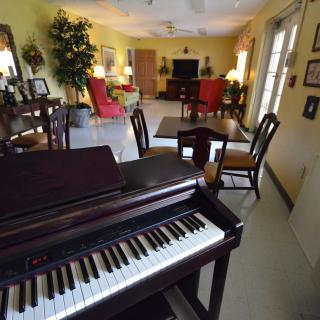 A cozy living room with a piano and elegant furnishings.