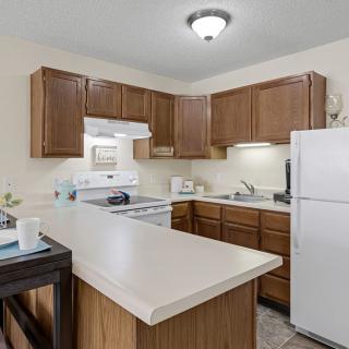 A modern kitchen interior with wooden cabinets and white appliances.