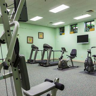 A clean and well-lit gym featuring treadmills, stationary bikes, and other exercise equipment.