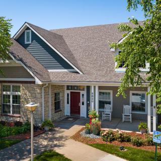 A charming suburban house with a well-maintained garden and inviting front porch.