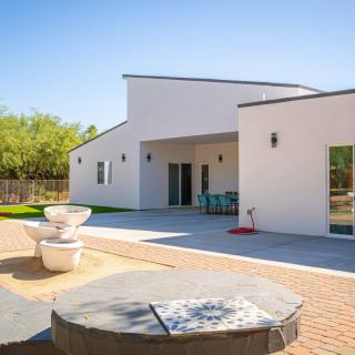A modern house with a minimalist design featuring a spacious backyard patio and outdoor seating.