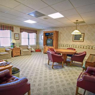 A cozy living room with comfortable seating, a table, and a television.