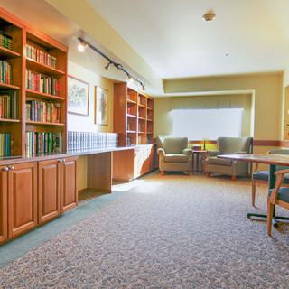Cozy library reading area with bookshelves and comfortable seating.