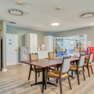 A modern dining or conference area with a large table and several chairs in a well-lit room.