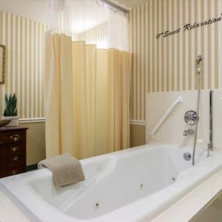 A modern bathroom with a large bathtub and surrounding curtains.