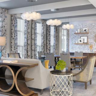 A modern dining room with contemporary decor featuring unique pendant lights, stylish furniture, and patterned curtains.