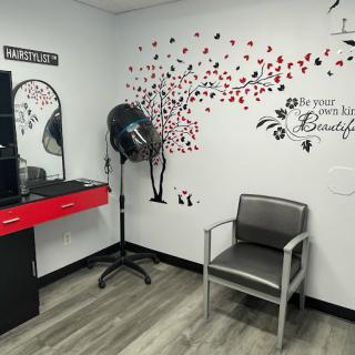 A cozy beauty salon corner featuring a hair dryer, mirror, and stylish wall art.